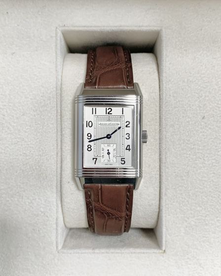 Jaeger-LeCoultre Reverso aus Stahl mit silbernem Zifferblatt, arabischen Ziffern und kleiner Sekunde an einem braunen Lederarmband in einer hellen Uhrenbox