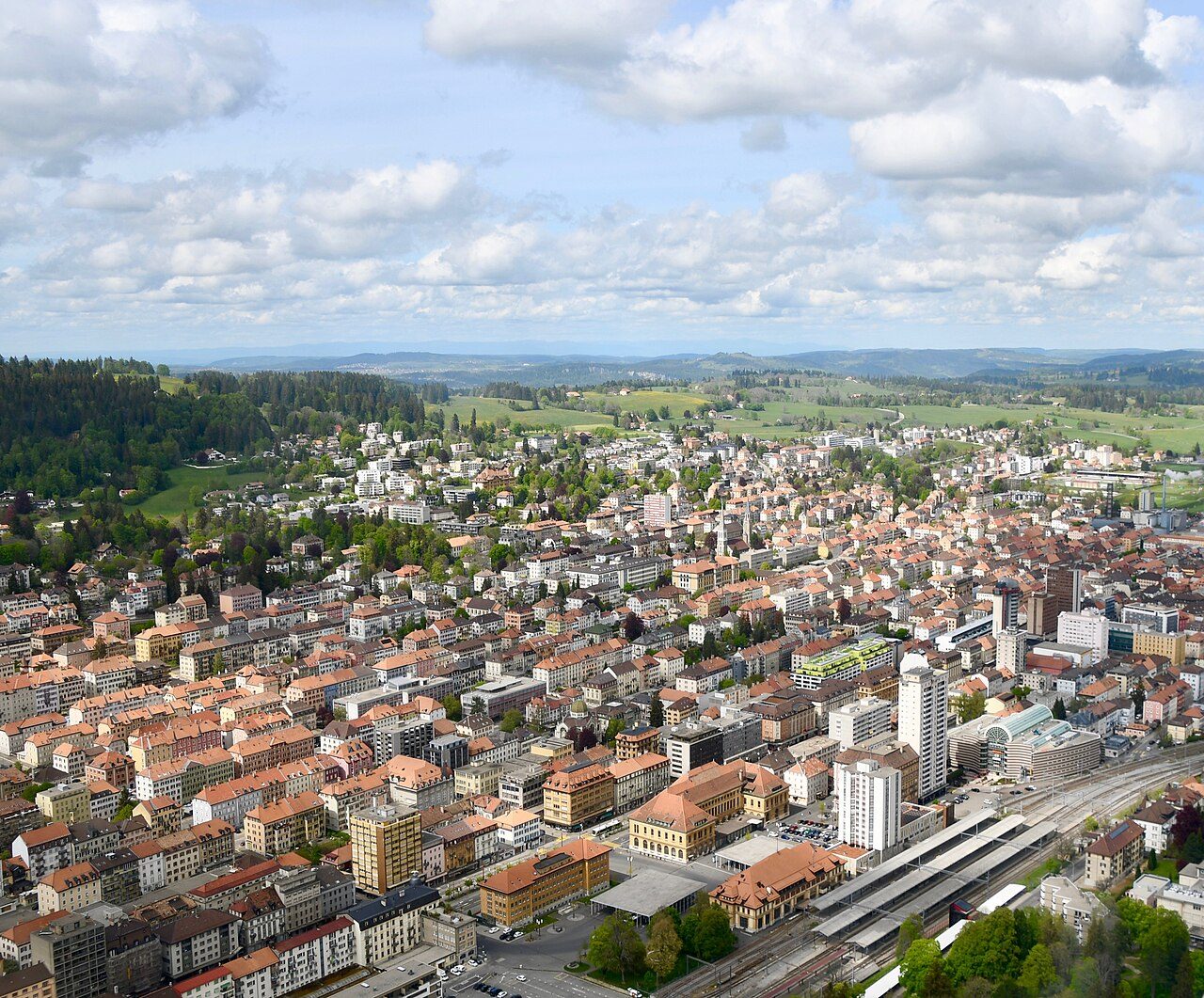 Luftbild von La Chaux-de-Fonds mit den parallelen, rasterförmig angelegten Strassenzügen der Uhrmacherstadt