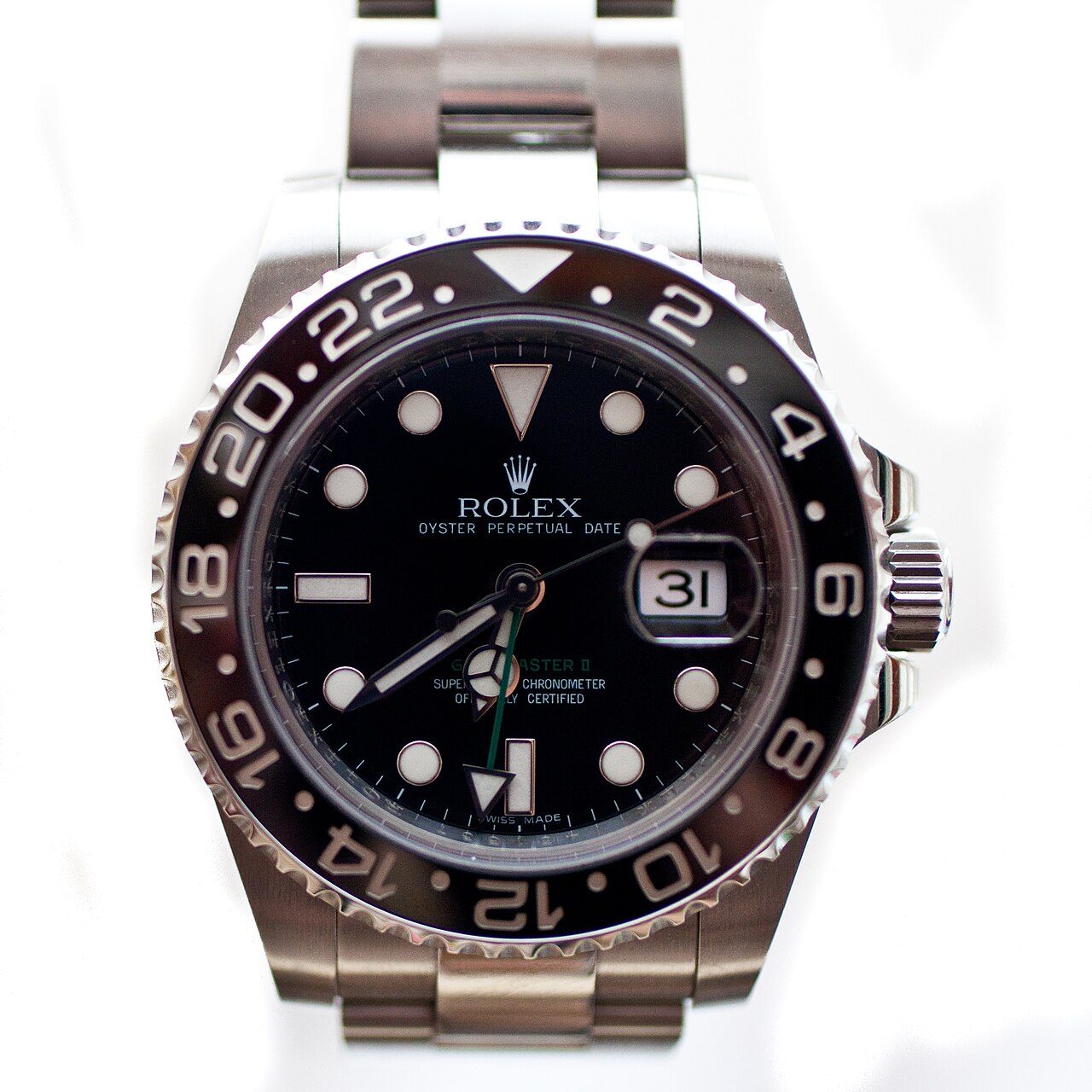 Rolex GMT-Master II aus Stahl mit schwarzer Lünette mit 24-Stunden-Skala, schwarzem Zifferblatt, Datumsfenster mit Lupe und grünem 24-Stunden-Zeiger vor hellem Hintergrund